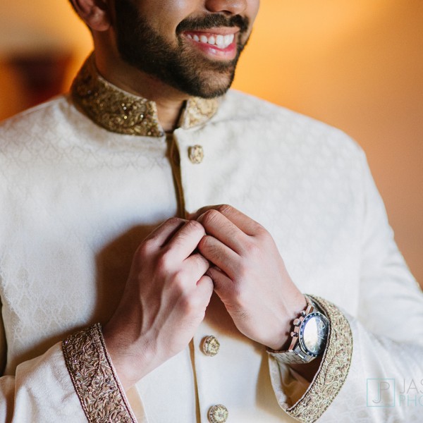 groom putting on his sherwani