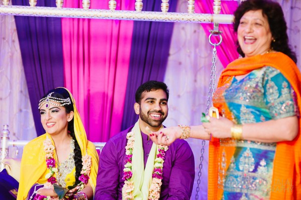 bride and groom sitting on a colorful swing