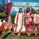 Indian bride walking down the aisle with her teal and red wedding colors displayed behind her